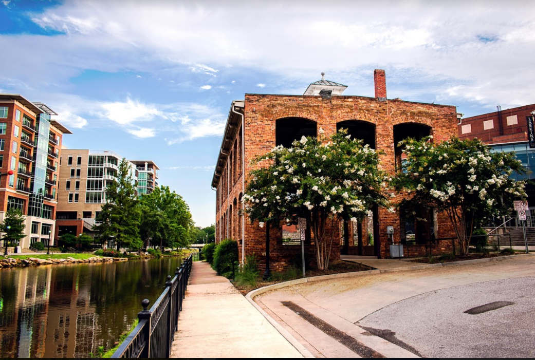 Historical brick building on the canal with flowering trees in downtown Greenville South Carolina