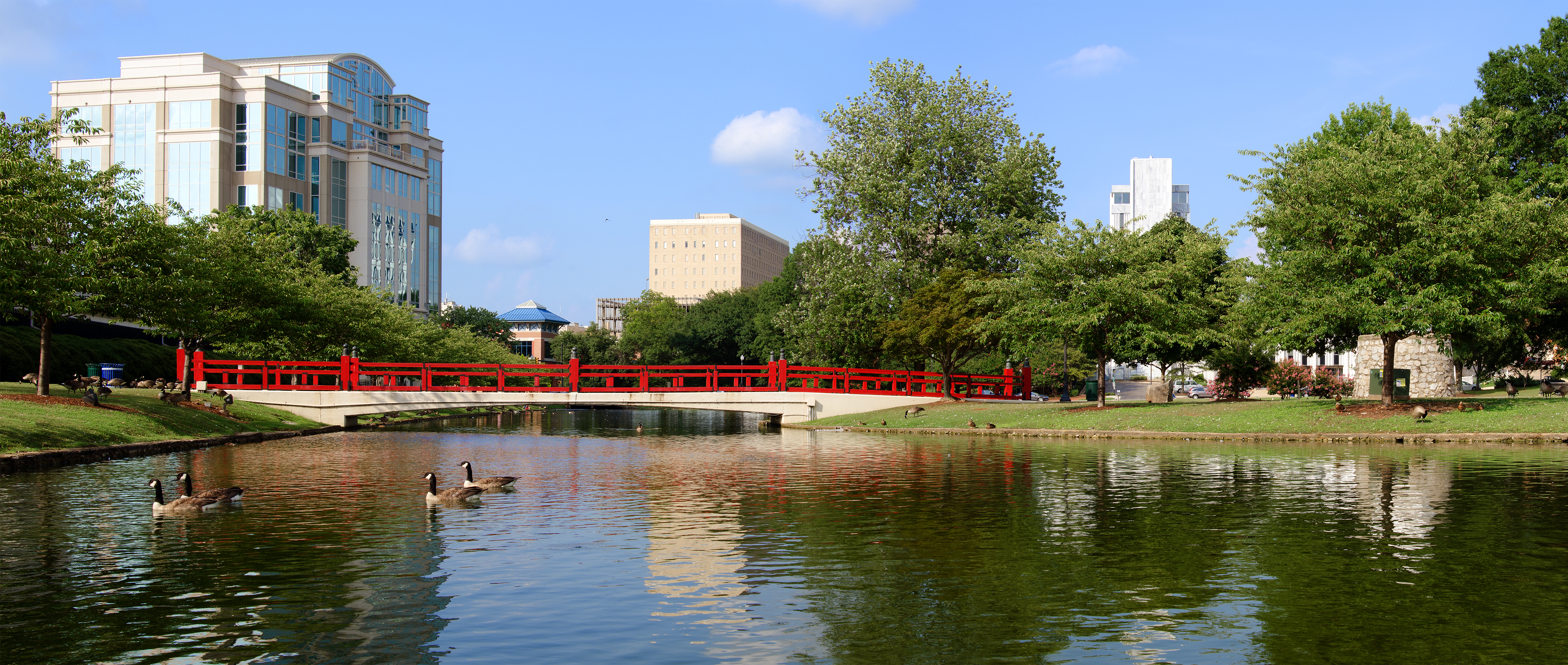 red walking bridge over lake with geese in Big Spring Park Huntsville Alabama
