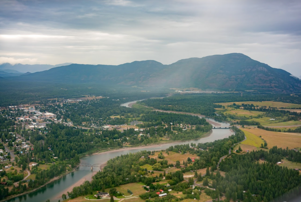Aerial view of Kalispell showing the river in foreground and mountains in background