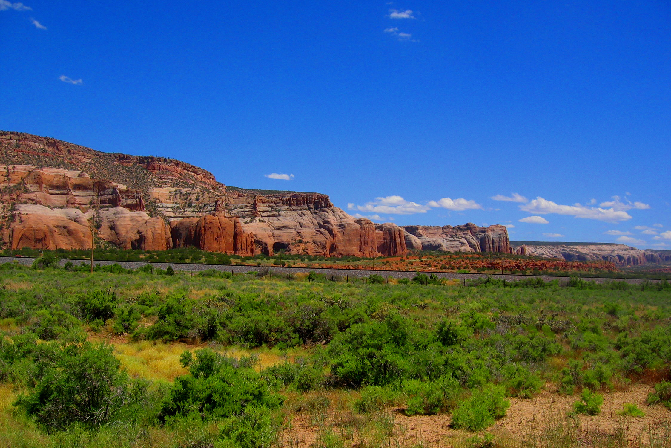 Desert scrub and mountains in the background on a clear day