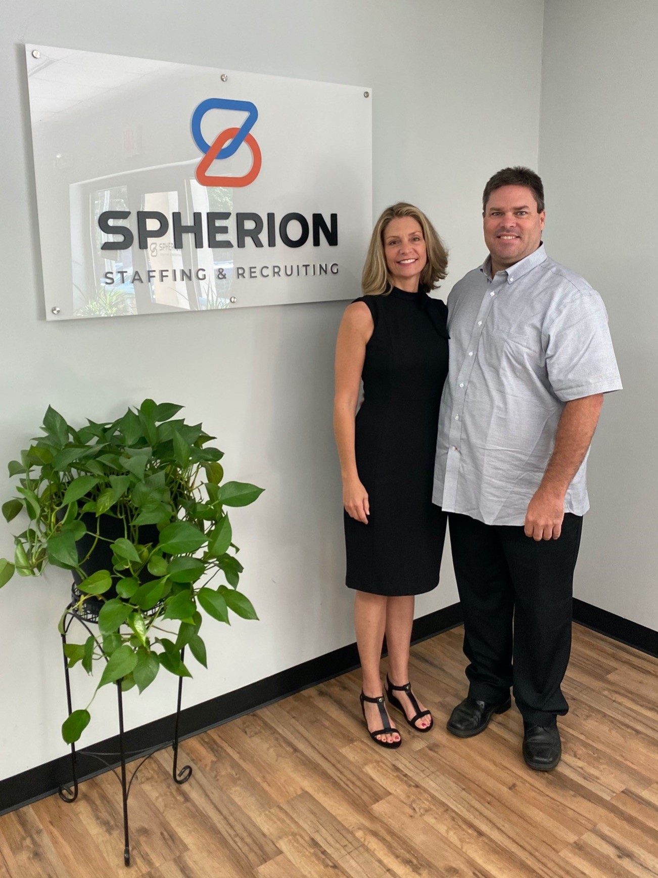 Molly & Joe Keebler posing in front of a Spherion brand banner