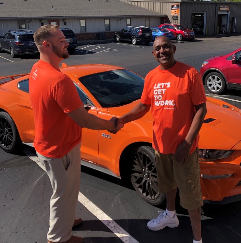 Spherion Works Sweepstakes Winner Michael P. shaking hands with Scott after receiving his new orange Ford Mustang GT