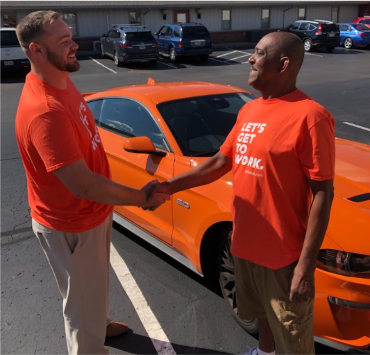 Spherion Works Sweepstakes Winner Michael P. with his new orange Ford Mustang
