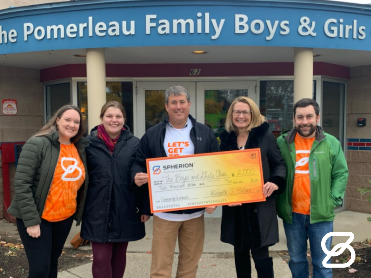 The Spherion Vermont team poses in front of the Pomerleau Family Boys and Girls Club with their Community Giveback donation check.