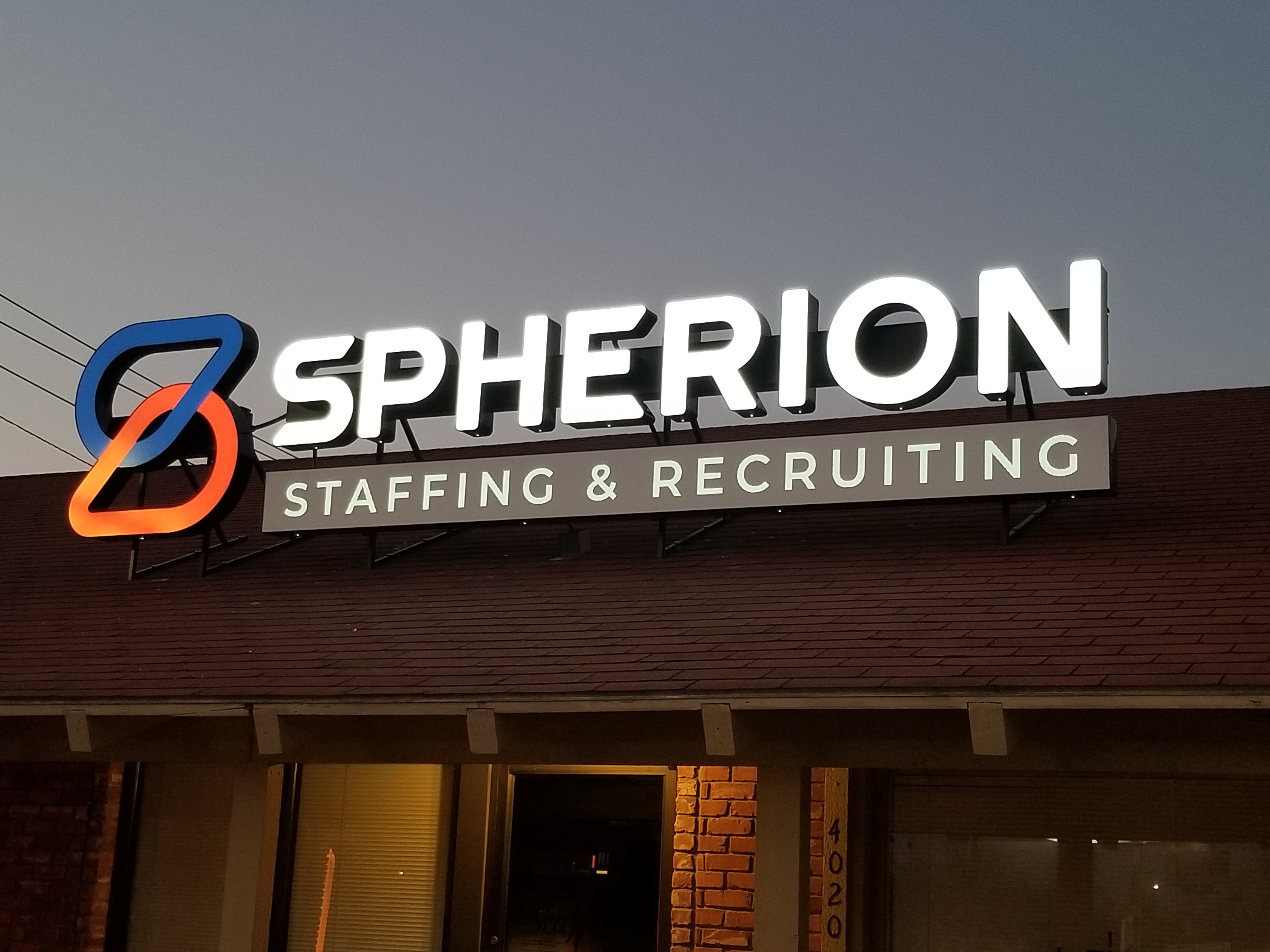 Spherion sign outside the Wichita Falls, TX office against a twilight sky