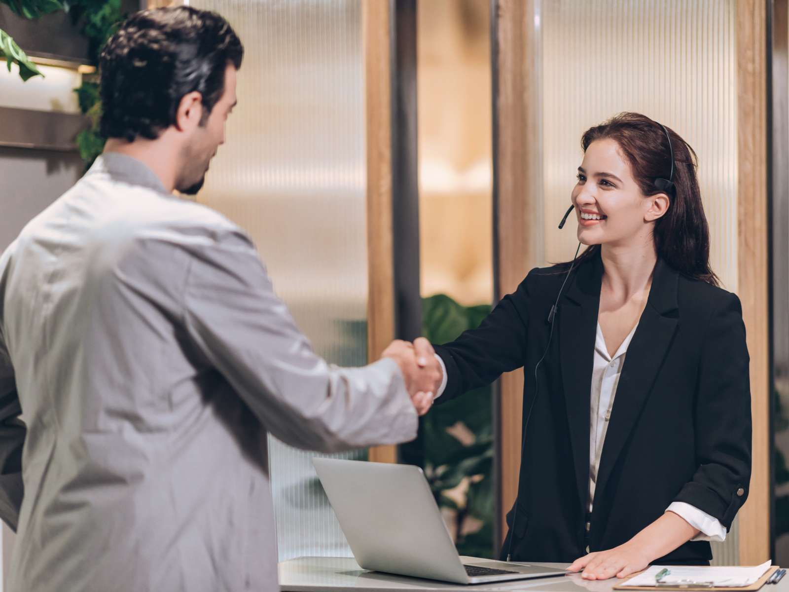 Female_receptionist_shaking_hands_with_male_visitor