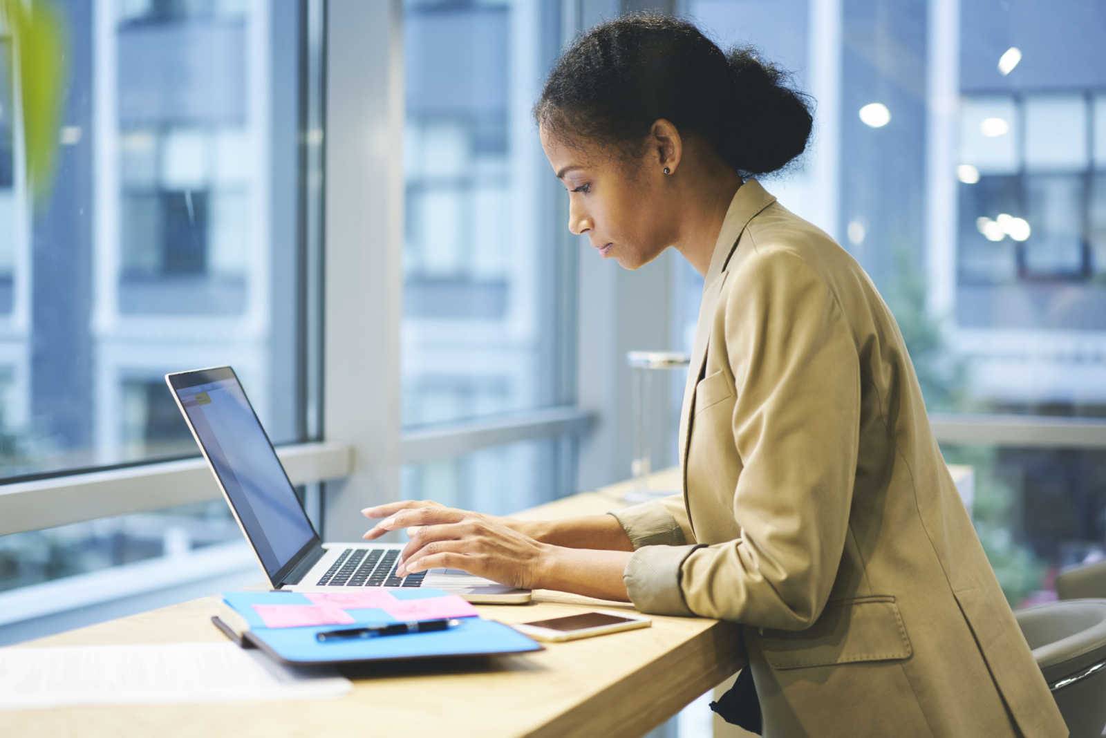 Woman looking at a computer wearing a headset and smiling