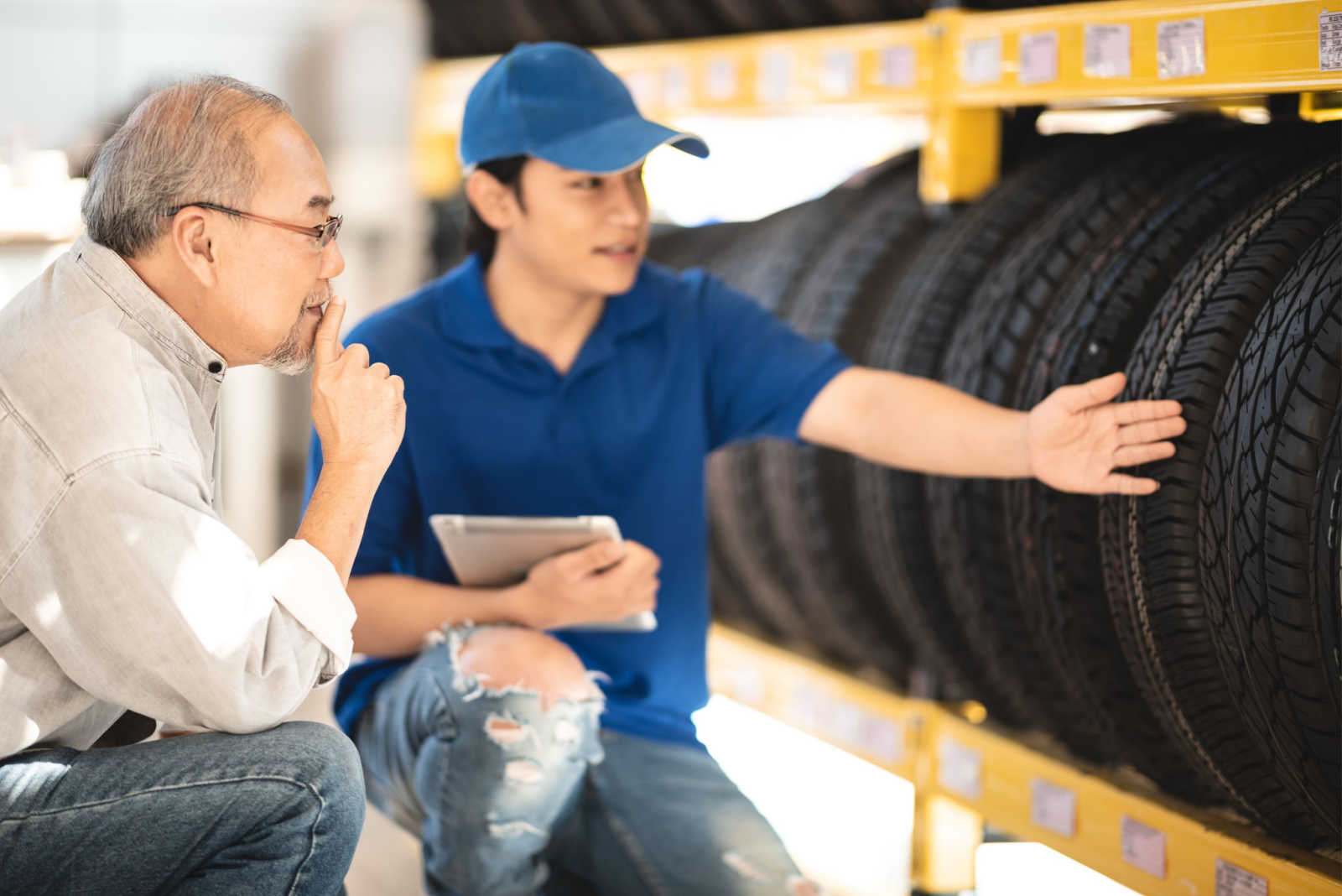 sales representative showing a customer a row of tires