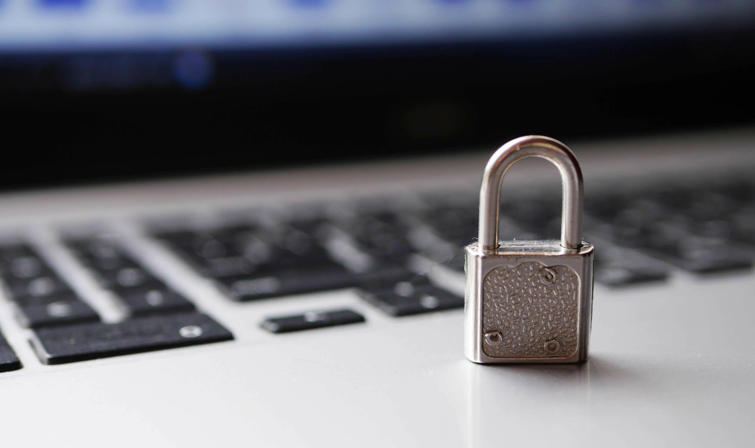 Blurry close-up image of a laptop with a silver padlock on top of the keyboard