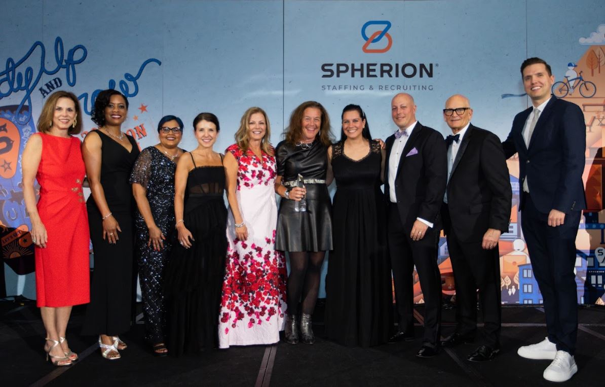 A row of people standing on a stage during an awards presentation