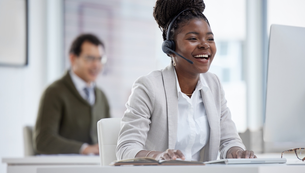 Shot of a young businesswoman wearing a headset while working on a computer in an office