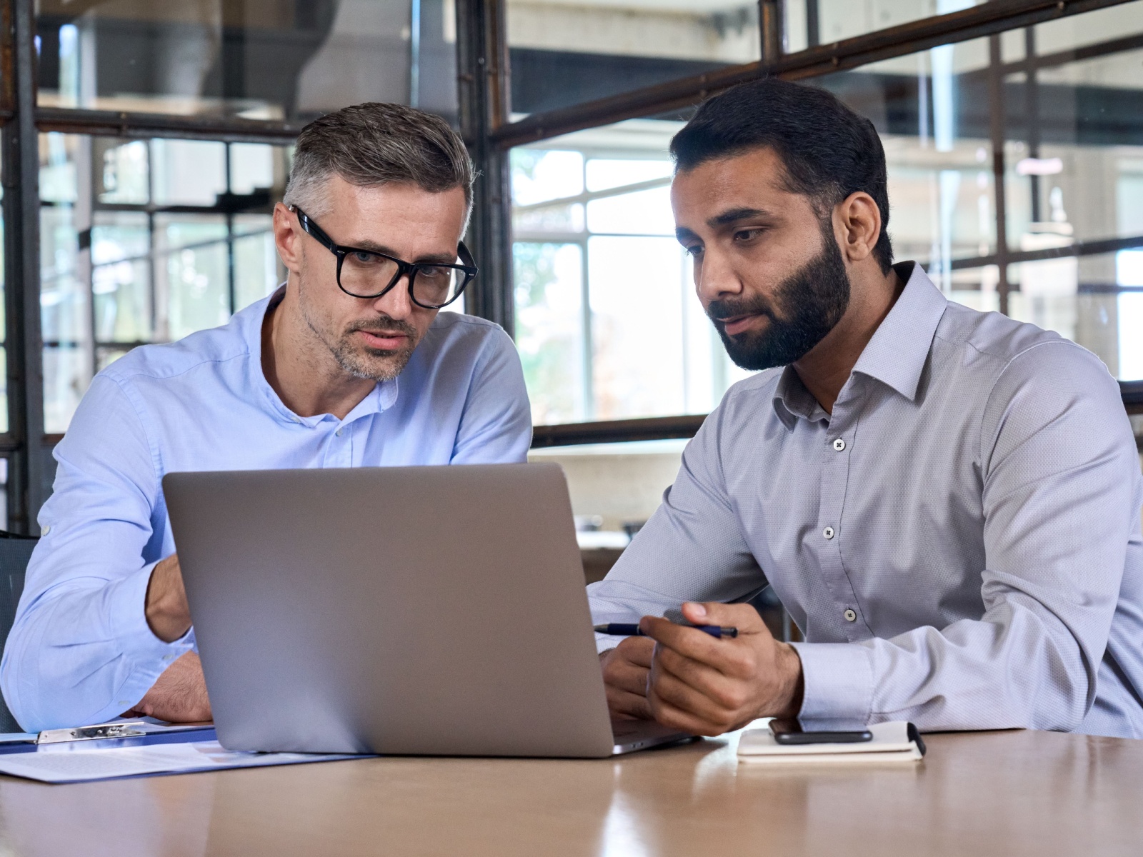 Two businessmen looking at a laptop in an office setting