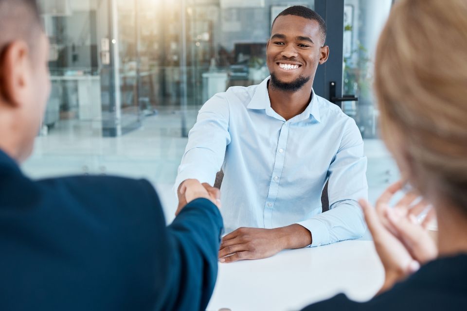 Interviewers shaking hands with a new onboarding employee