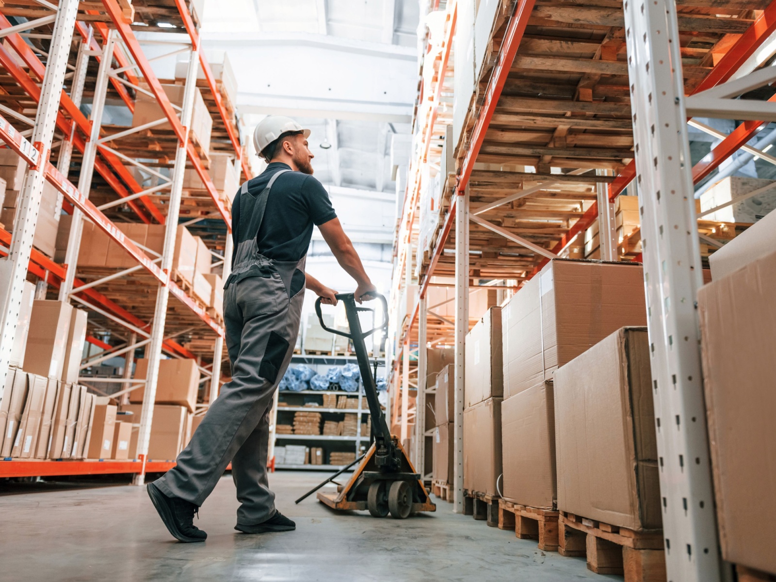 Employee in uniform is working in the storage at daytime