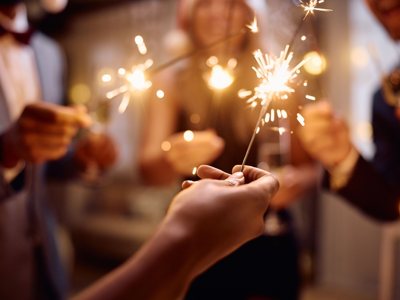 Close-up of a group of people holding sparklers at a party