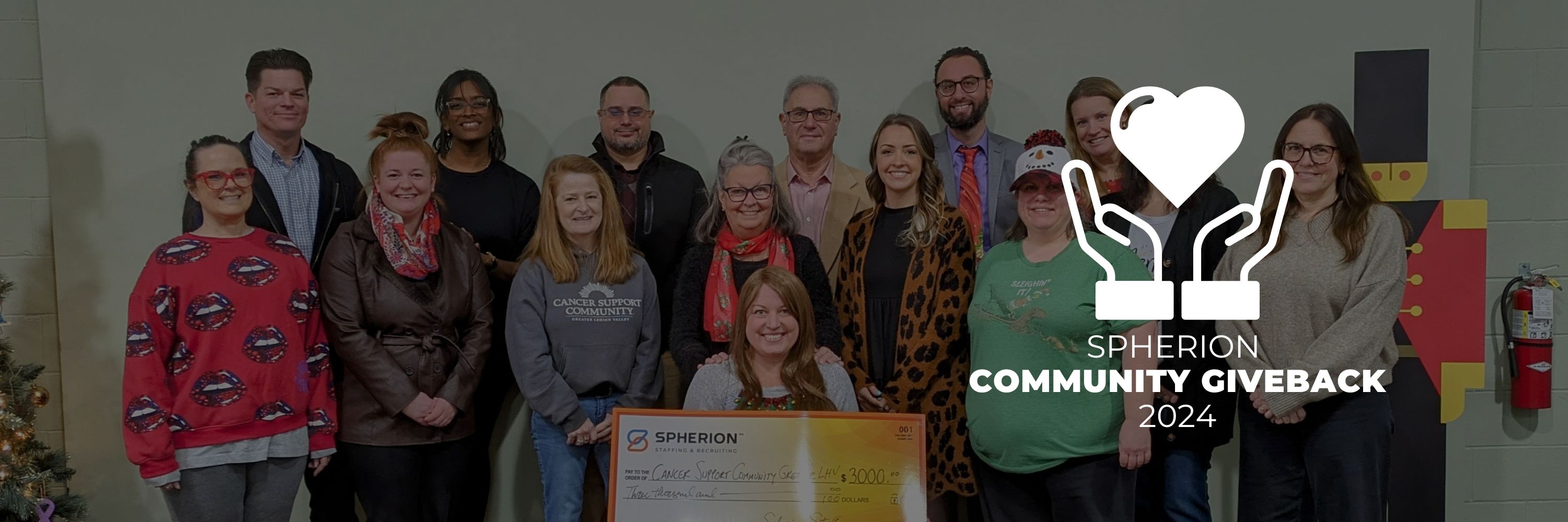 A group of professionals presenting a check to a nonprofit organization
