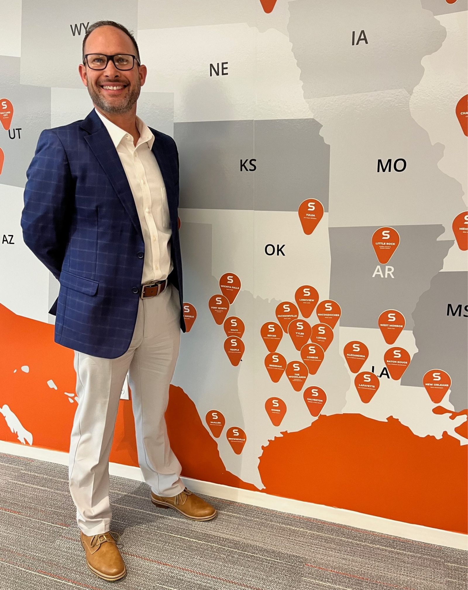 Brandon Cook standing in front of a map of the US