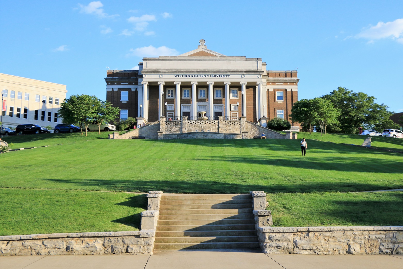 Wide-view photo of a classical-style building with columns on a hilltop