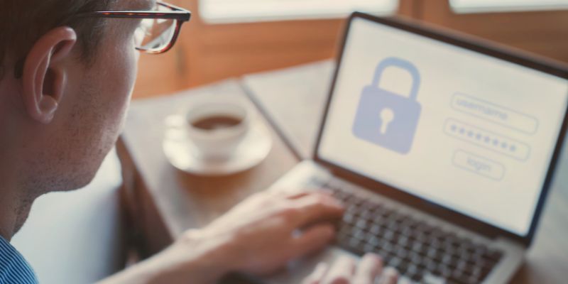 Close-up of a man logging into a website on a laptop