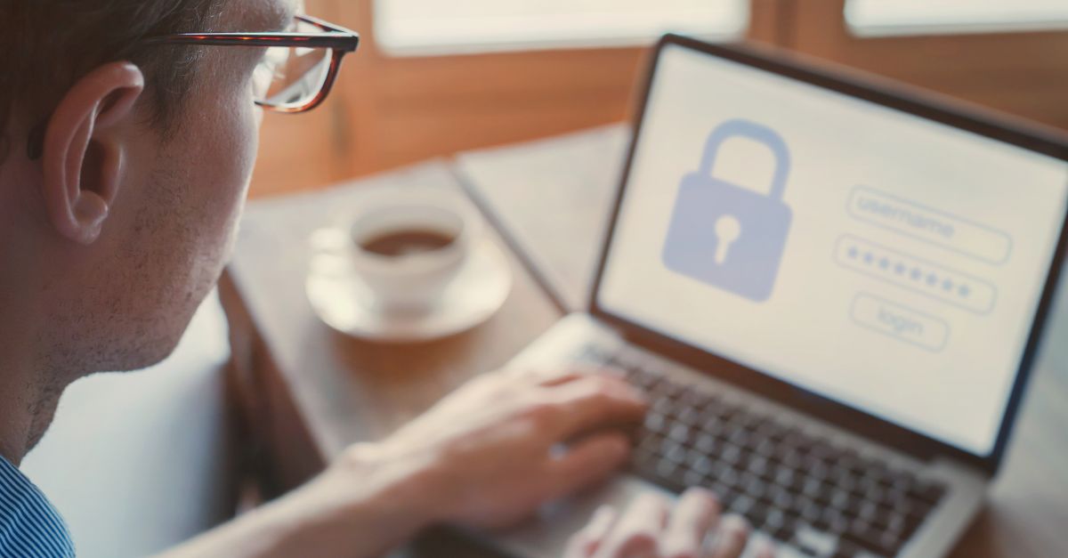 Close-up of a man logging into a website on a laptop