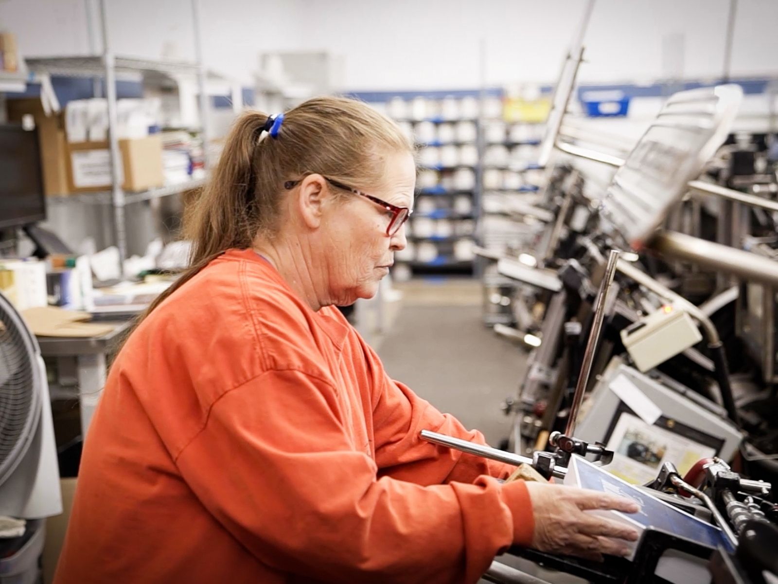 Photo of a woman working in a printing warehouse