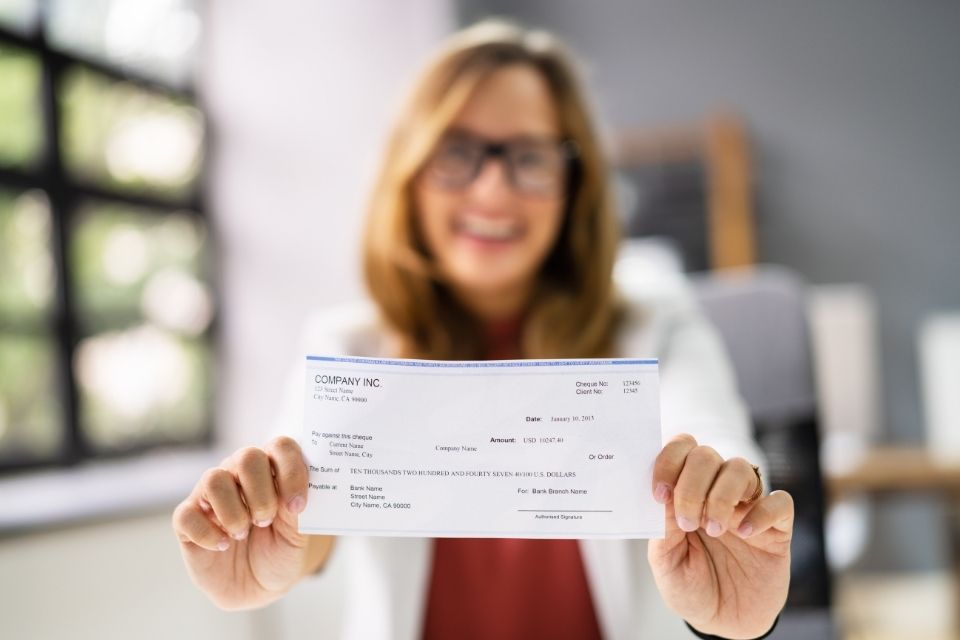Blurred photo of a woman holding a paycheck