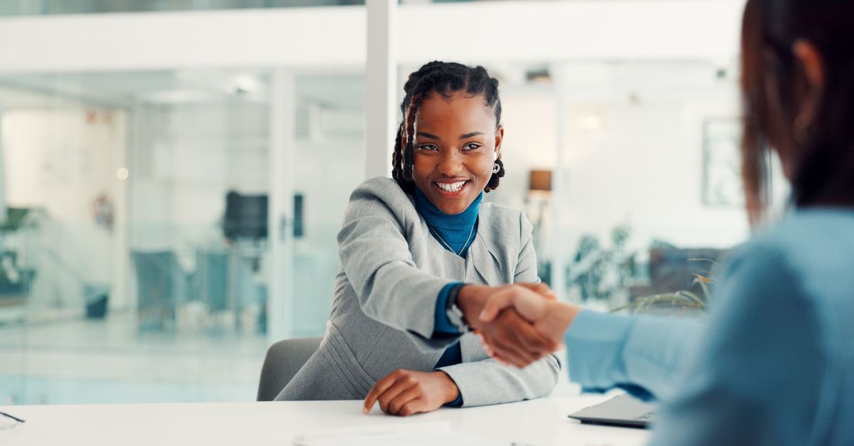 Two women shaking hands at an office