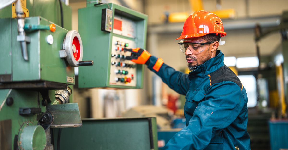 A man in an orange hard hat operating a machine