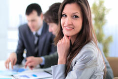 Woman in business suit smiling with people in background