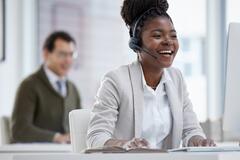 Shot of a young businesswoman wearing a headset while working on a computer in an office