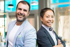 A man and woman standing back to back and smiling