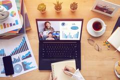 Aerial view of a laptop and marketing analytics sheets on a desk