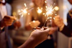 Close-up of a group of people holding sparklers at a party
