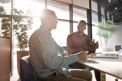 Two businessmen discussing plans in a modern workspace