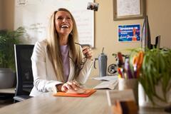 A professional woman sitting at a desk and smiling