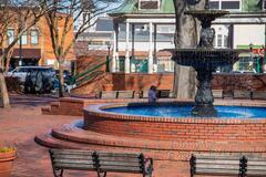 View of an outdoor brick public square with a fountain and gazebo