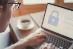 Close-up of a man logging into a website on a laptop