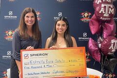 Two women celebrating the awarding of a scholarship check