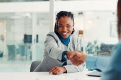 Two women shaking hands at an office