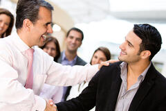 Two men in a business meeting congratulating one another.