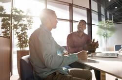 Two businessmen discussing plans in a modern workspace