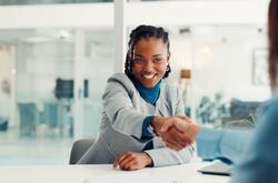 Two women shaking hands at an office