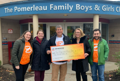 The Spherion Vermont team poses in front of the Pomerleau Family Boys and Girls Club with their Community Giveback donation check.