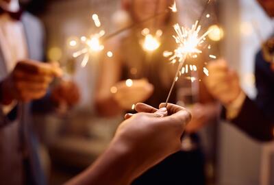 Close-up of a group of people holding sparklers at a party