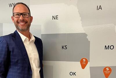Brandon Cook standing in front of a map of the US