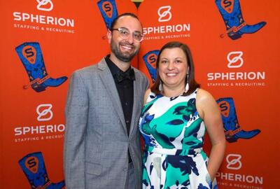 A couple standing against an orange background