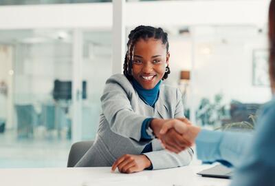 Two women shaking hands at an office