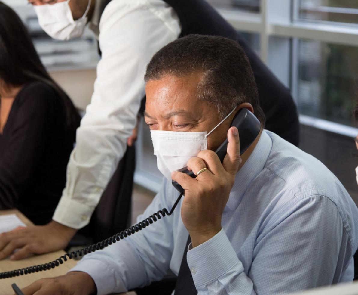 Man talking on a phone wearing a white face mask