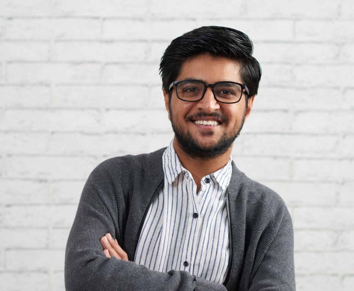 Middle Eastern Man with arms crossed smiling at the camera