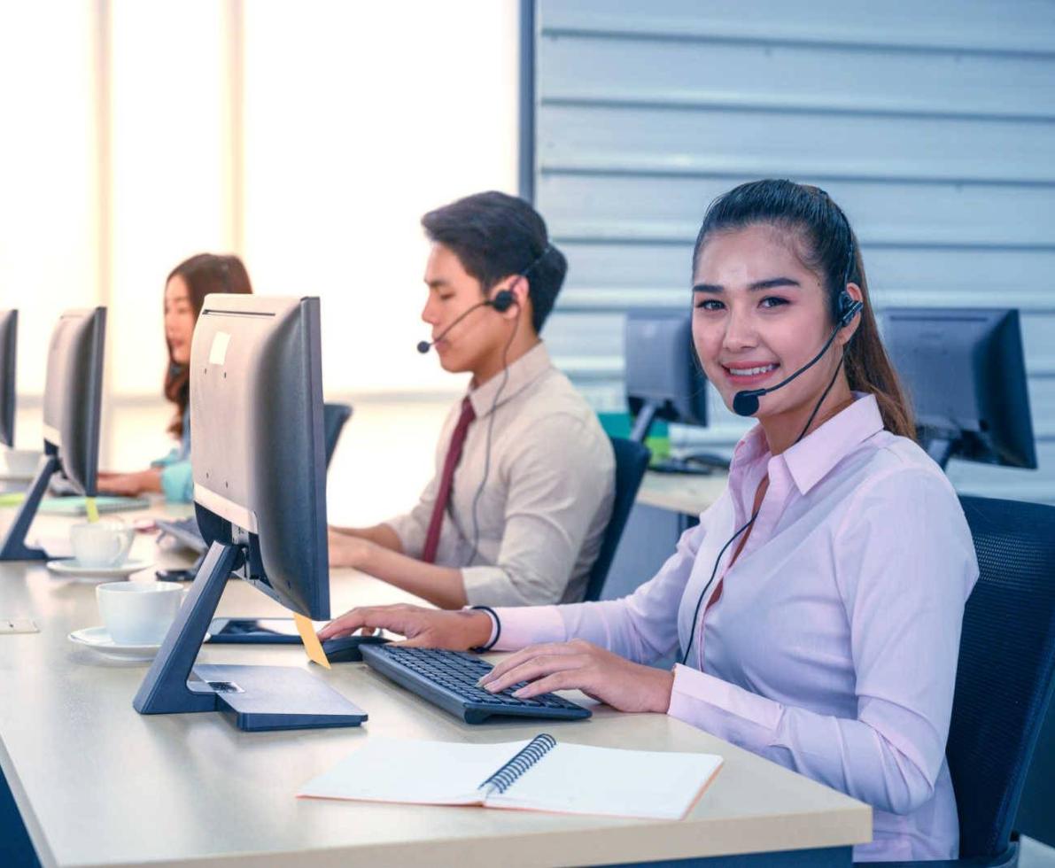 Woman working at a call center smiling at her workstation